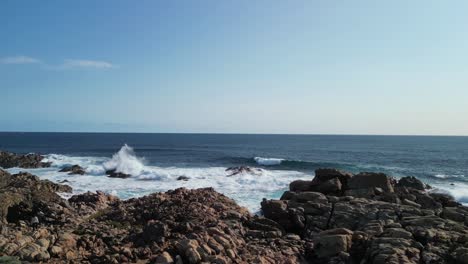 person contemplating yallingup canal with waves crashing into rocks, australia