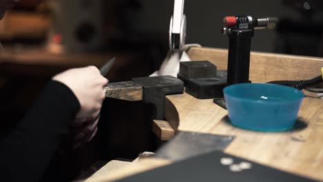 Shot-of-a-female-metalworker-filing-a-silver-metal-necklace