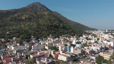 beautiful aerial shot of housing area bordering huge mountain in india