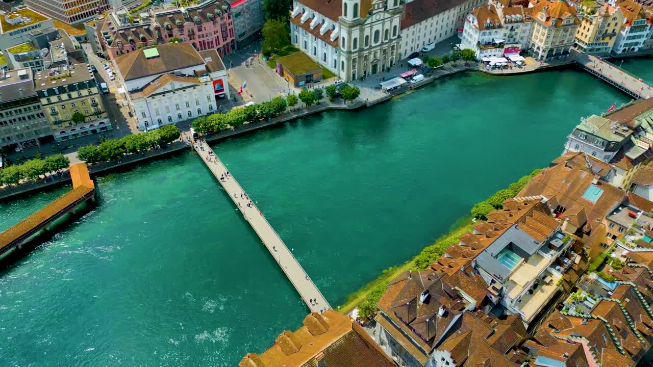 스위스 루체른의 루체른 호수 근처에 있는 라우스 강을 가로지르는 샤펠 다리와 라트하우스테그 다리의 4k 드론 영상.
