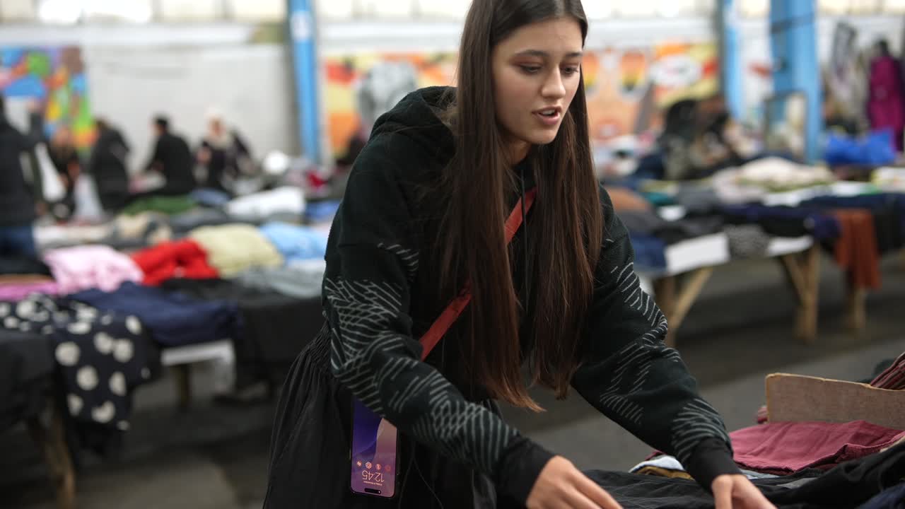 Giovane donna che fa shopping in un mercato dell'abbigliamento