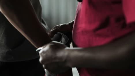 coach wearing boxing gloves to a boxer in the gym