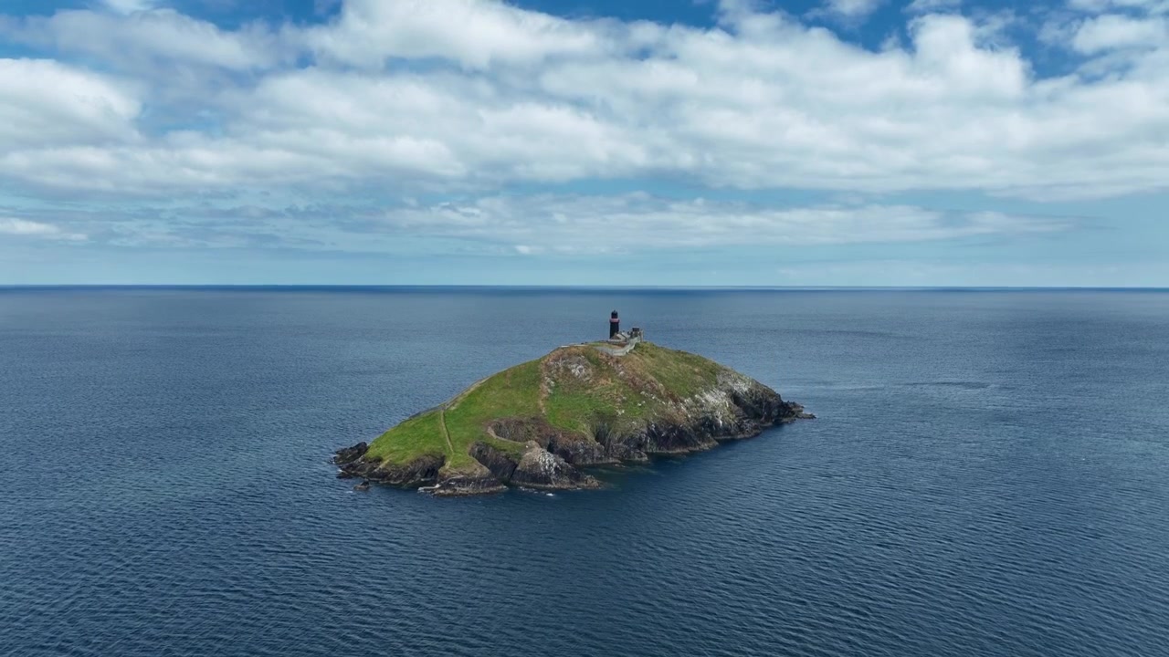 Drone in ascesa sul faro e l'isola di Ballycotton che avverte le navi transatlantiche della costa insidiosa della contea di Cork, Irlanda