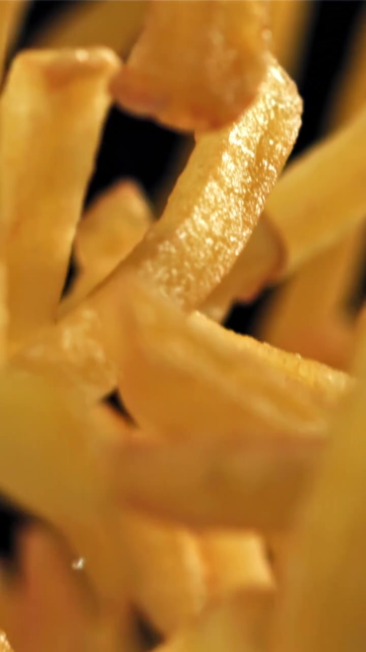 Crispy Golden French Fries Falling on Black Background
