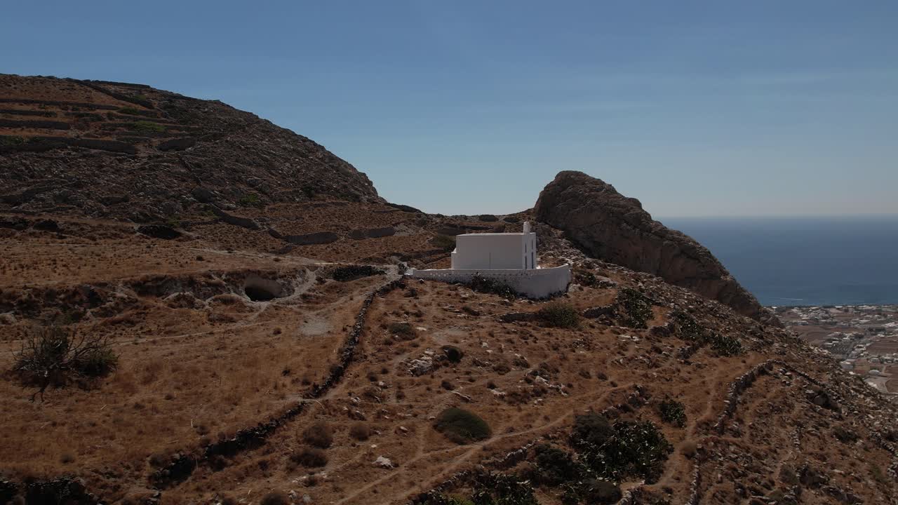 화창한 그리스의 산토리니 산에 있는 예배당 주변의 공중 전망 - 돌고, 드론 샷