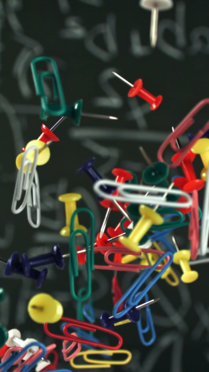 Colorful Office Supplies Falling in Slow Motion Against a Chalkboard