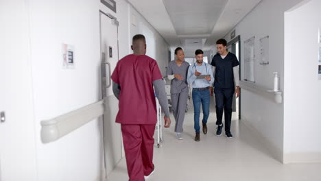 diverse healthcare professionals walk in a hospital corridor