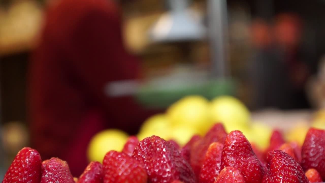 Donna che prepara succo di frutta fresco in un mercato