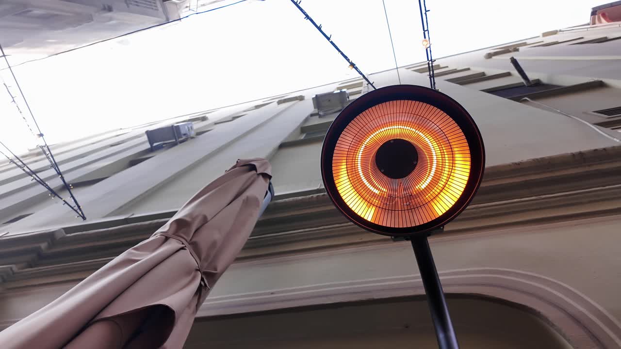 Stufa elettrica da esterno che emana una calda luce arancione