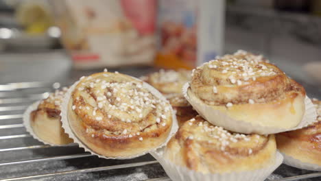 Männliche-Hand,-Die-Ein-Zimtbrötchen-Im-Hintergrund-Unscharf-Aufhebt