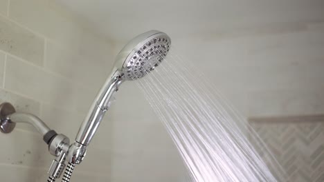 chrome shower head is turned on where hot water comes out and then turned off again