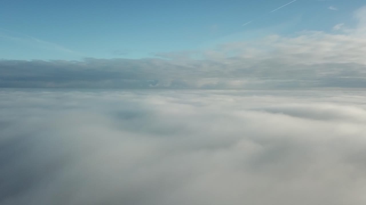 rising throug the fogy clouds to the clear blue sky above
