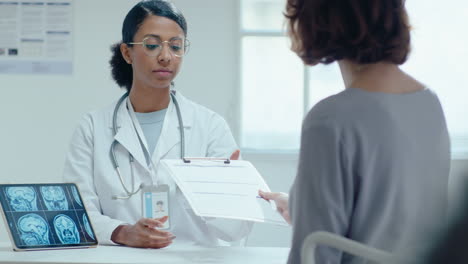 female doctor taking medical agreement and shaking hands with patient in clinic