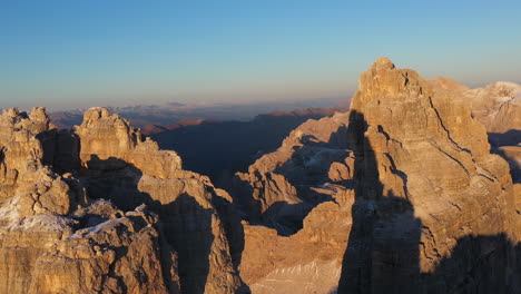 revealing cinematic drone of the tre cime di lavaredo in italy, with wilderness mountain ranges in the distance