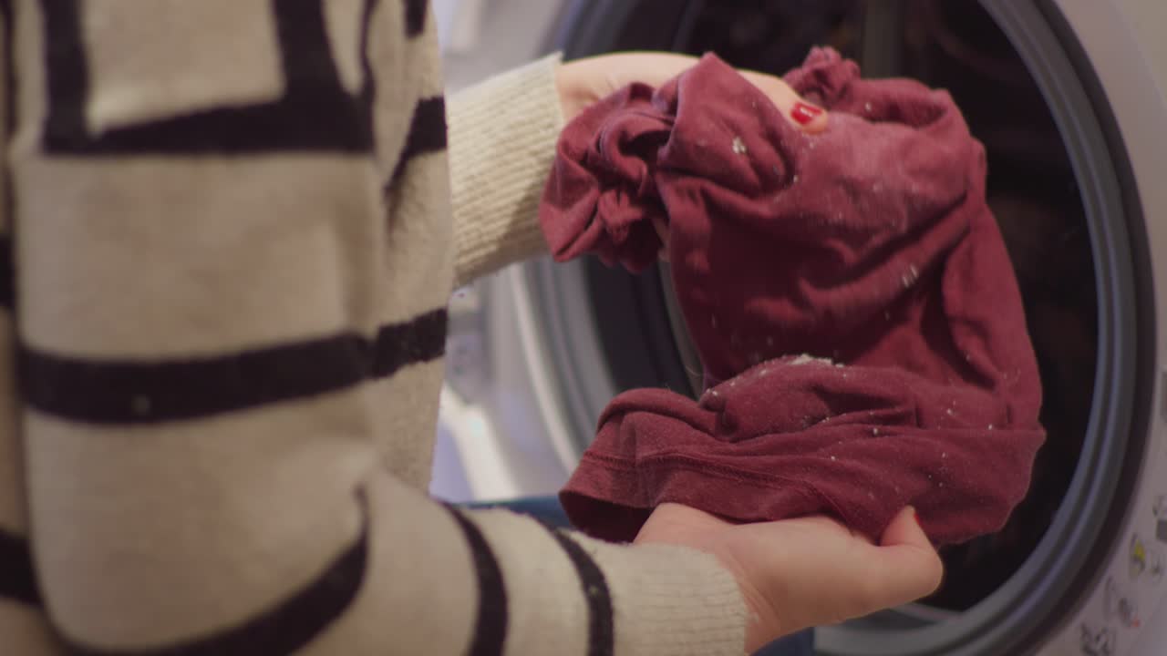 Hands Taking Out Clothes with Detergent Residue from Washing Machine