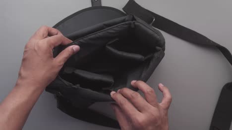 inspecting a black messenger bag