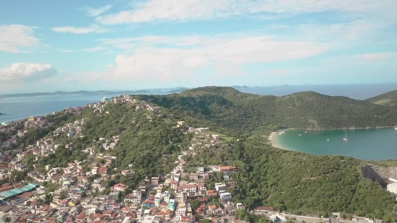 Aerial drone shot of Arraial do Cabo town built on the cliffs with the dreamy landscape surrounding it in Brazil