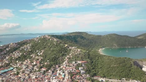 aerial drone shot of arraial do cabo town built on the cliffs with the dreamy landscape surrounding it in brazil