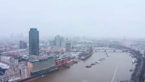 Luftdrohnenaufnahme-Im-Schnee-Von-London,-Südufer,-Waterloo-Brücke,-London-Eye