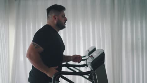 sterke man training cardio-oefening op de machine van de loopband in slow motion zijaanzicht van de sportschool