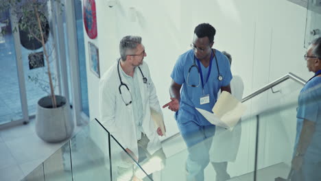 talking, doctor and nurse walking on stairs