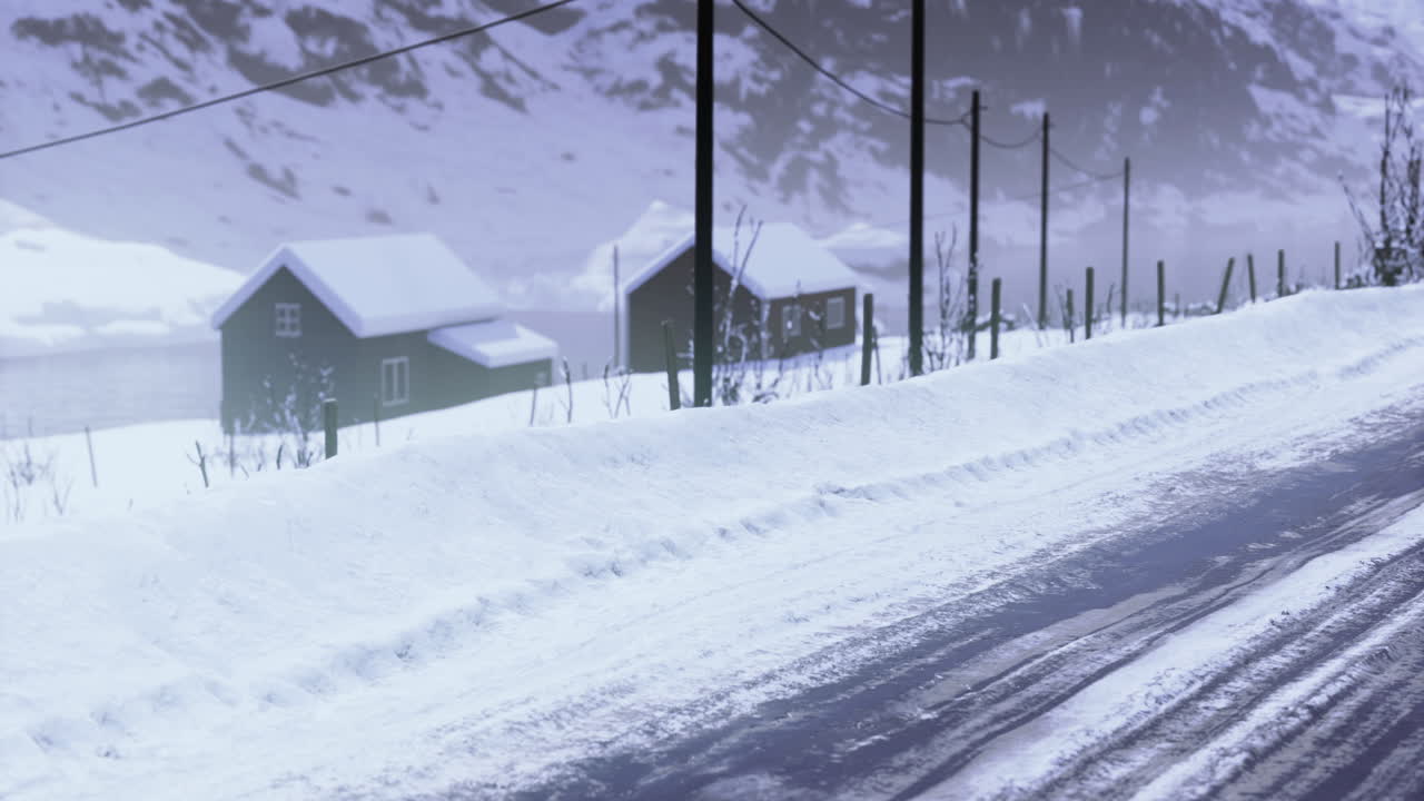 눈 인 도로는 평온한 겨울 풍경에서 멀리 있는 오두막으로 이어집니다.
