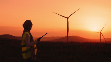 female engineer at wind farm sunset