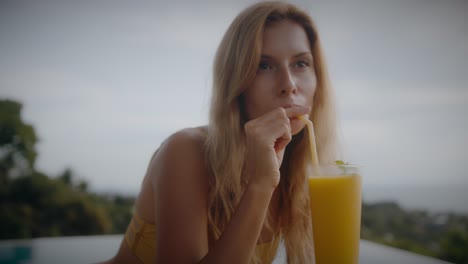 woman enjoying a tropical smoothie by the pool