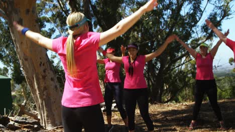 Female-trainer-assisting-women-while-exercising-in-the-boot-camp