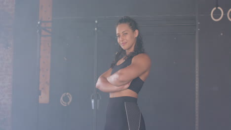 confident woman in gym wearing sportswear, crossing arms and smiling