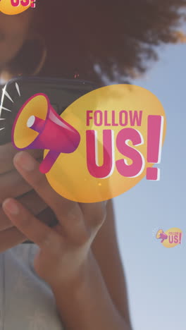 animation of follow us over midsection of happy biracial woman using smartphone outdoors