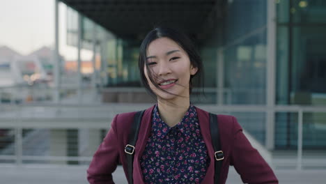 portrait of optimistic asian woman intern posing happy in city