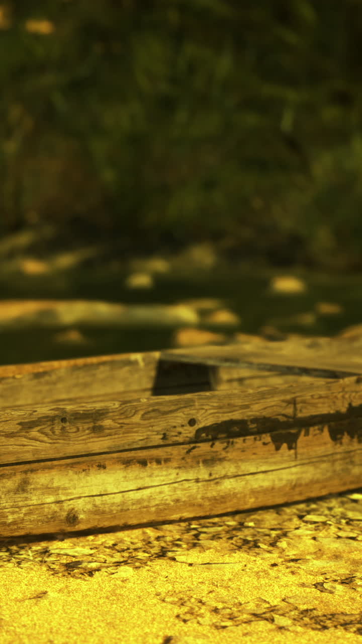 Barca di legno usurata appoggiata su una sponda sabbiosa sotto la calda luce del sole