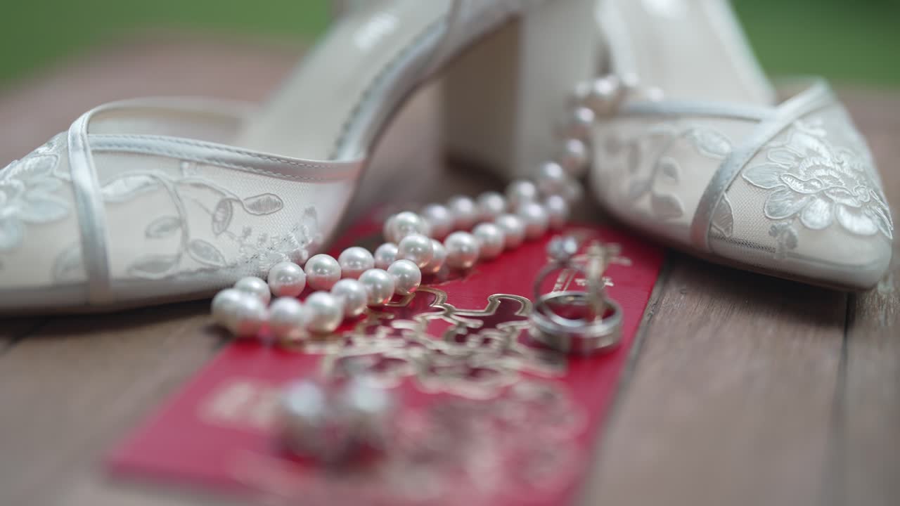Beautiful close-up shots of wedding details, including the bride's exquisite shoes, sparkling rings, intricate jewelry, and a delicate wedding invitation