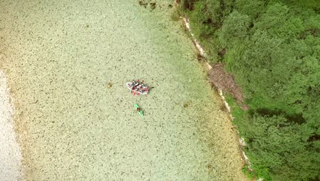 aerial view of a group of people doing rafting turquoise and transparent water.