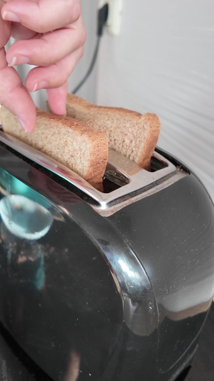 Taking Toasted Bread Out of Toaster in Home Kitchen