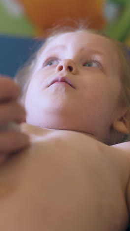 cu: female doctor touches unhappy little girl tummy with ultrasonography tool in modern clinic office close view