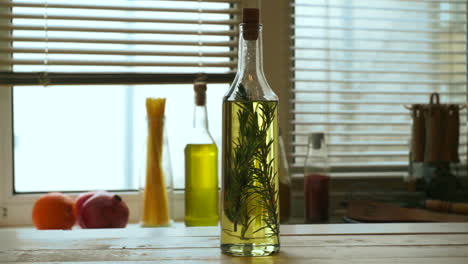 Olive-oil-bottle-on-kitchen-table.-Extra-virgin-olive-oil-with-rosemary