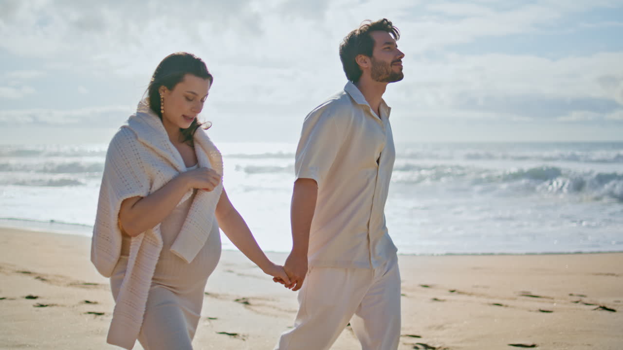 만적인 커플이 바가에서 산책하며 아기를 기다리고 있습니다. 임신 중인 배우자가 고 있습니다.