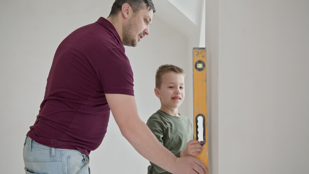 Father and Son Measuring Wall with Level
