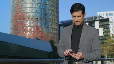 hombre de negocios escribiendo en el teléfono celular al aire libre. empleado enfocado caminando por la calle