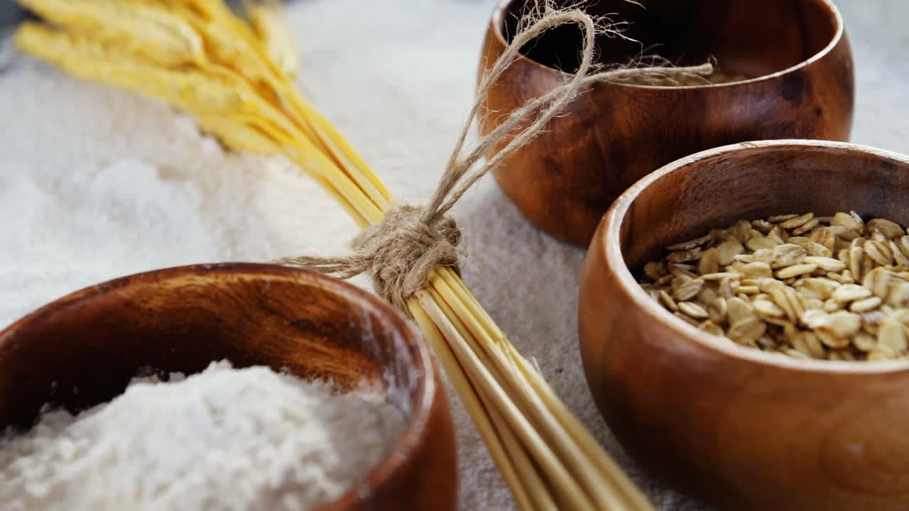 Wheat grains, sesame and flour in bowls