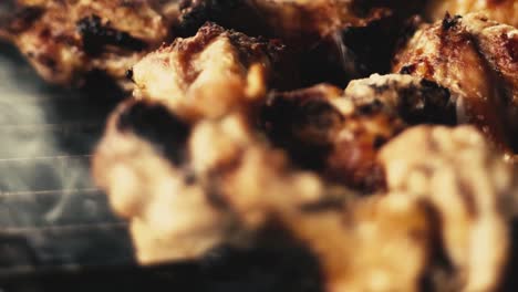 slow motion close-up shot of chicken wings and smoke from the charcoal grill