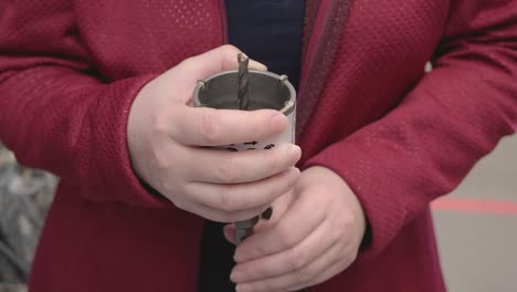 woman in store buys a drill for drilling niches for electrical outlets. close up