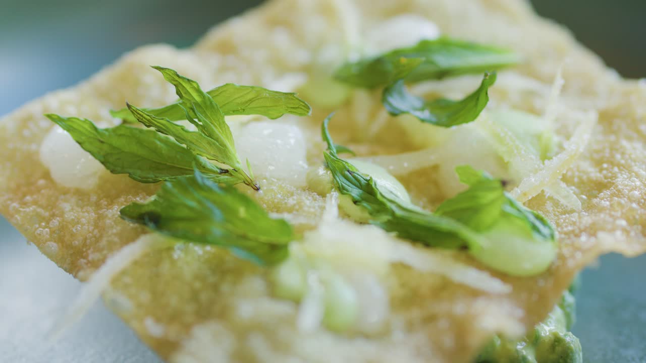 Close-up macro sequence of a fork and knife cutting into a crisp seafood crab cake garnished with fresh herbs, under soft natural lighting