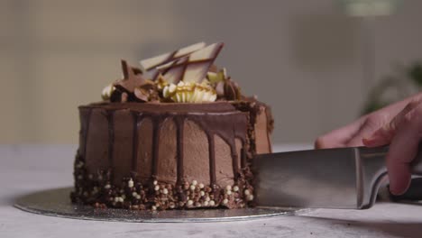 Nahaufnahme-Einer-Person-Zu-Hause,-Die-Eine-Scheibe-Vom-Schokoladenfestkuchen-Auf-Tisch-2-Schneidet