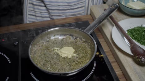 a chef puts yellow mustard into a metal pan