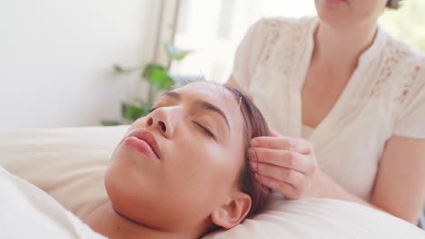 woman getting a head massage in a spa