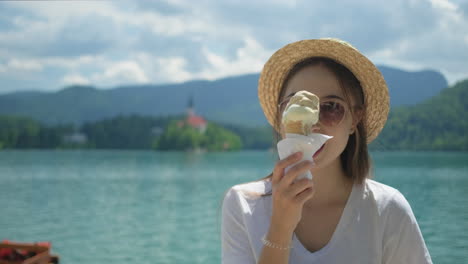 mujer disfrutando de helado junto al lago
