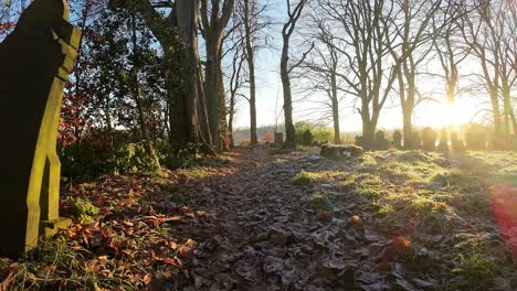 fpv flying around headstones in autumn snowy sunrise churchyard cemetery during golden hour